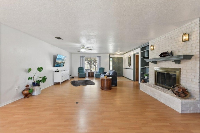 unfurnished living room featuring light wood-style floors, a fireplace, and a textured ceiling