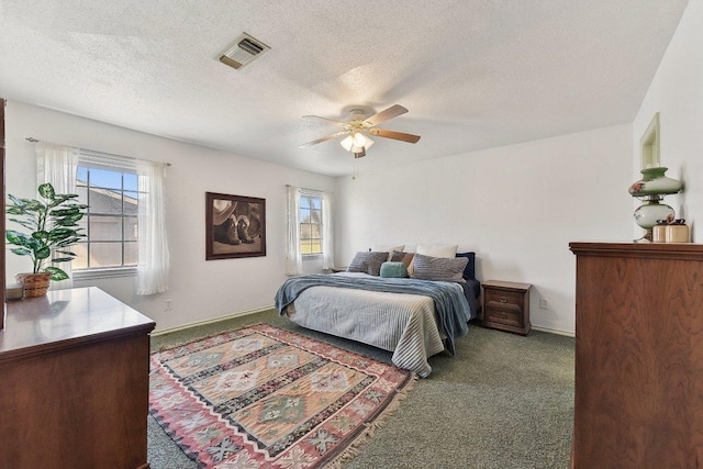 bedroom featuring a textured ceiling, visible vents, baseboards, a ceiling fan, and carpet