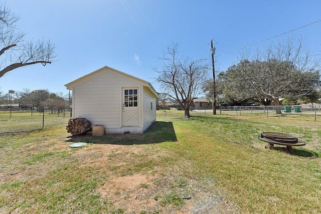 view of yard with a storage shed, an outdoor fire pit, fence, and an outdoor structure