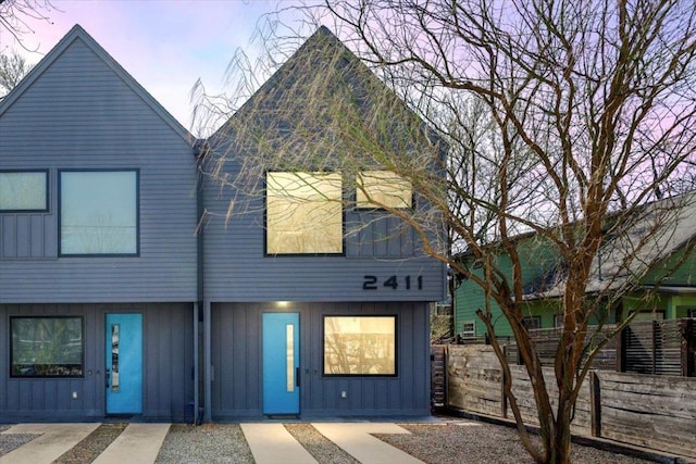 view of front facade with board and batten siding and fence