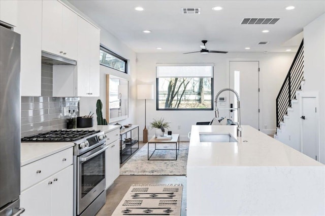 kitchen with stainless steel appliances, visible vents, a sink, and tasteful backsplash