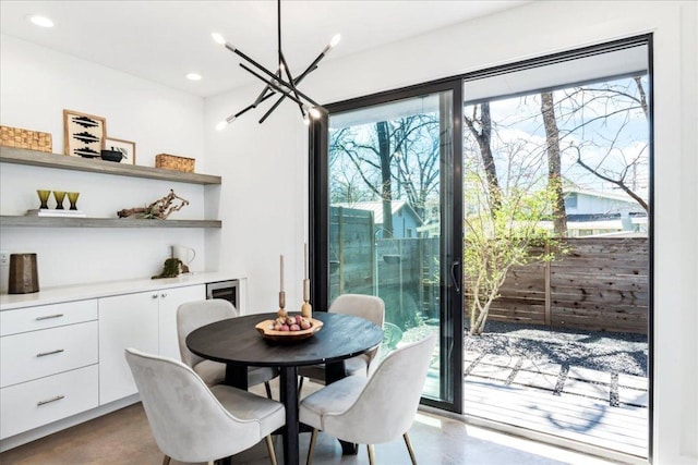 dining area with finished concrete flooring, a chandelier, and recessed lighting