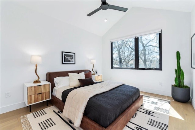 bedroom featuring lofted ceiling, light wood-style floors, ceiling fan, and baseboards