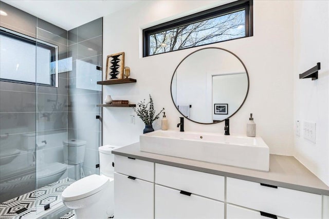 bathroom with toilet, a shower stall, and vanity