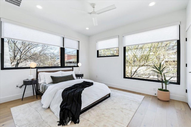 bedroom featuring baseboards, visible vents, wood finished floors, and recessed lighting