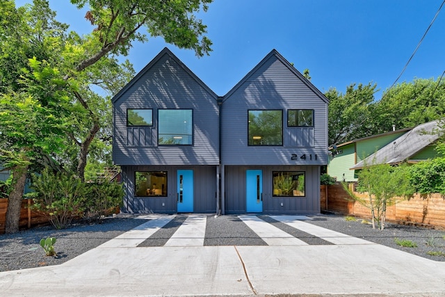 view of front facade with board and batten siding and fence