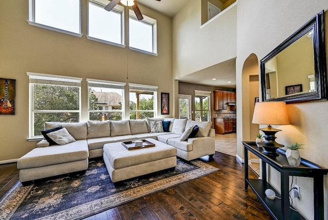 living area with baseboards, a ceiling fan, and hardwood / wood-style floors