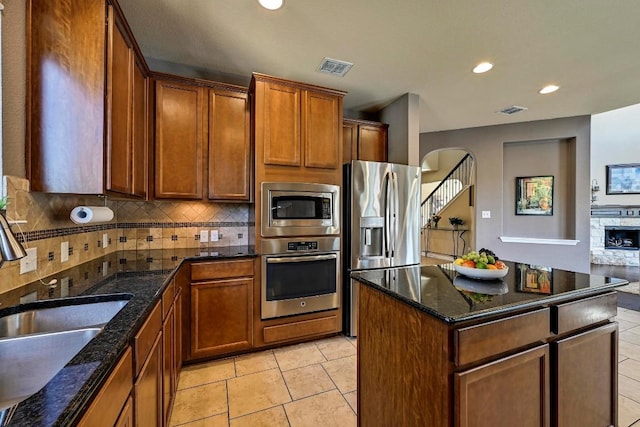 kitchen featuring light tile patterned floors, visible vents, decorative backsplash, appliances with stainless steel finishes, and a sink