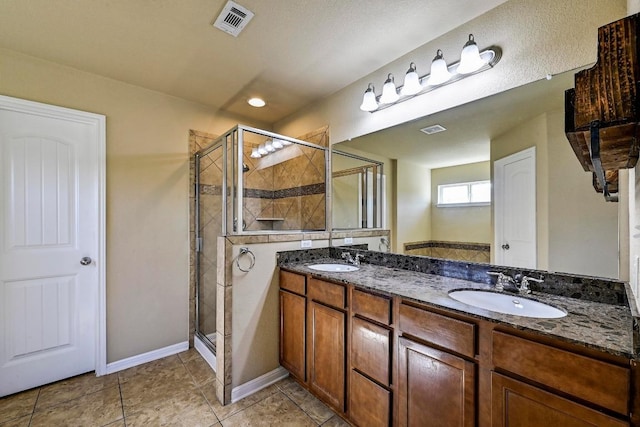 bathroom with visible vents, a sink, and a shower stall