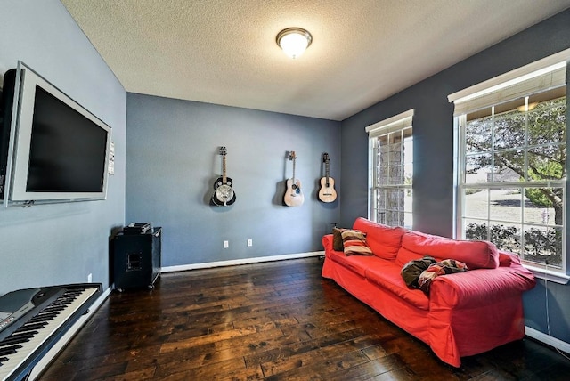 sitting room with wood-type flooring, baseboards, and a textured ceiling