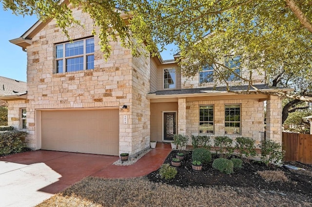 view of front of home with an attached garage, stone siding, and concrete driveway