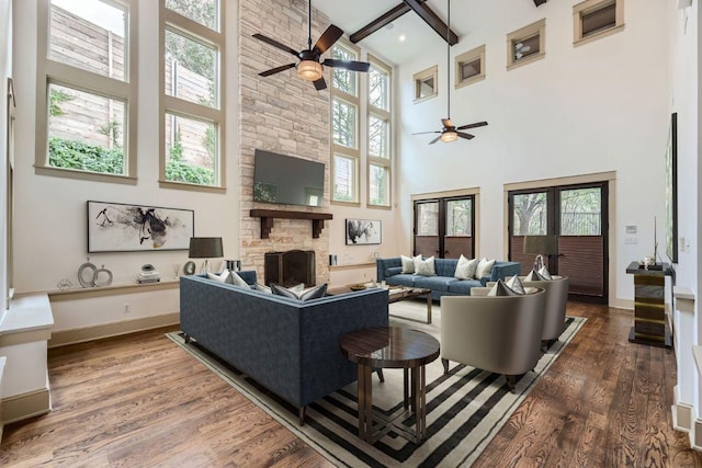 living area featuring a fireplace, wood finished floors, and baseboards