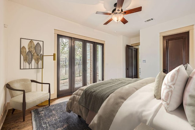 bedroom with access to exterior, visible vents, ceiling fan, and wood finished floors