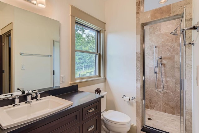 bathroom with vanity, a shower stall, and toilet