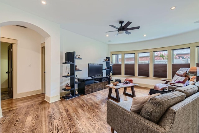 living room featuring arched walkways, recessed lighting, wood finished floors, visible vents, and baseboards