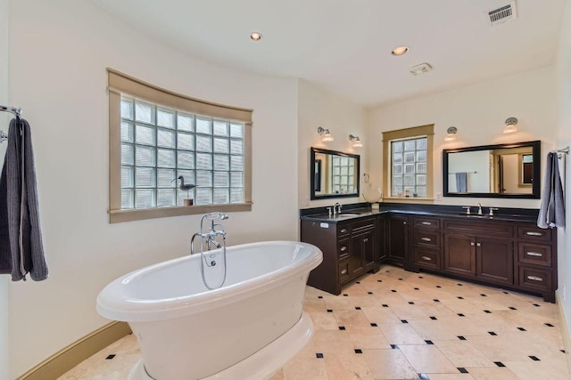 bathroom featuring recessed lighting, a soaking tub, visible vents, and vanity