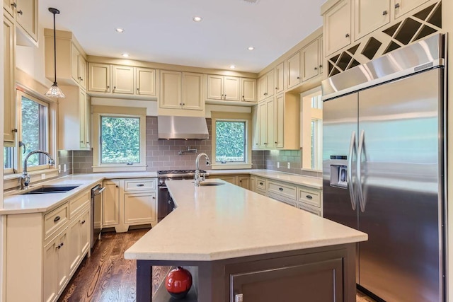 kitchen featuring stainless steel appliances, plenty of natural light, a sink, and decorative backsplash