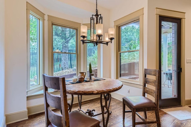 dining area featuring a notable chandelier, wood finished floors, and baseboards