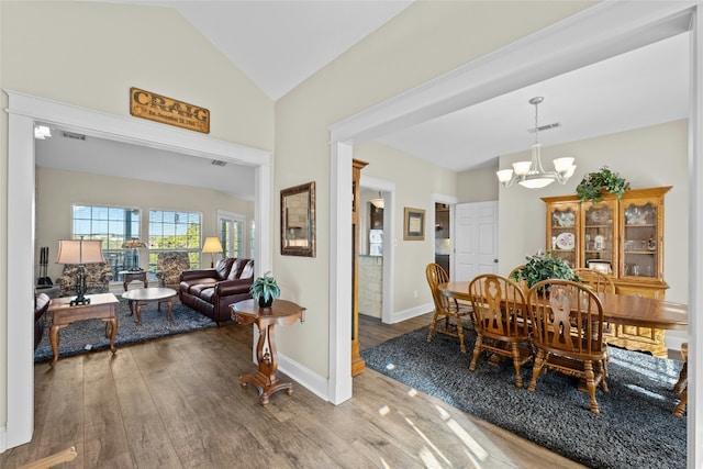 dining room featuring baseboards, visible vents, wood finished floors, vaulted ceiling, and a notable chandelier