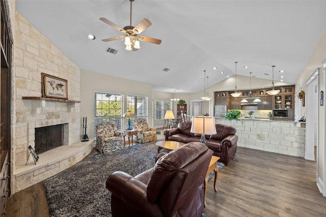 living room featuring high vaulted ceiling, a fireplace, visible vents, a ceiling fan, and dark wood finished floors