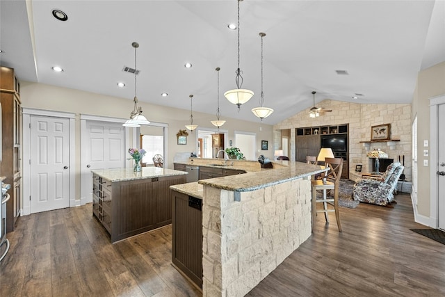 kitchen with visible vents, lofted ceiling, a spacious island, dark wood-style floors, and a sink