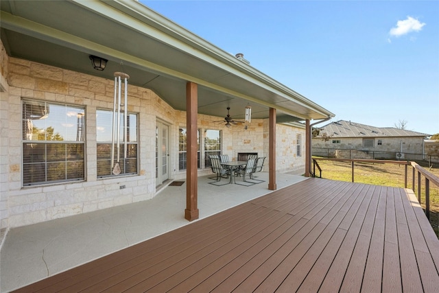 wooden terrace with ceiling fan, fence, and outdoor dining area