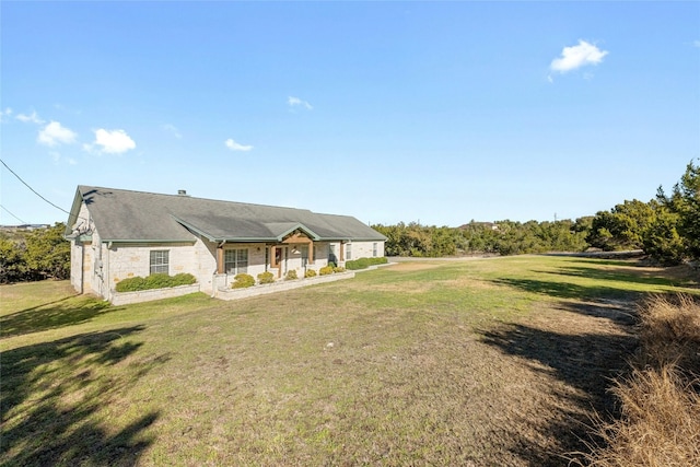 view of front facade with stone siding and a front lawn