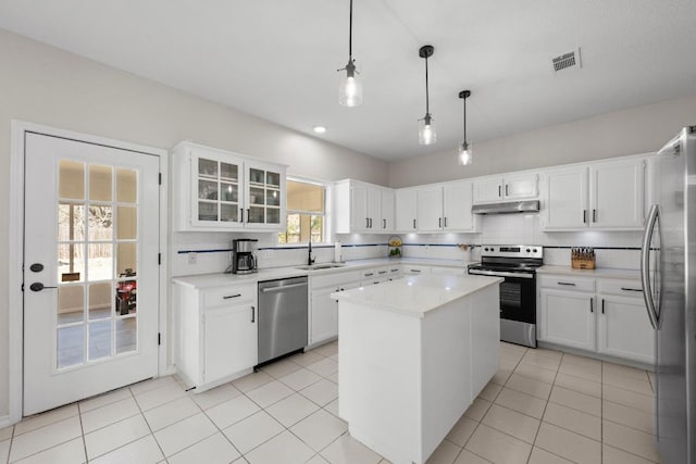 kitchen with a sink, stainless steel appliances, backsplash, and under cabinet range hood