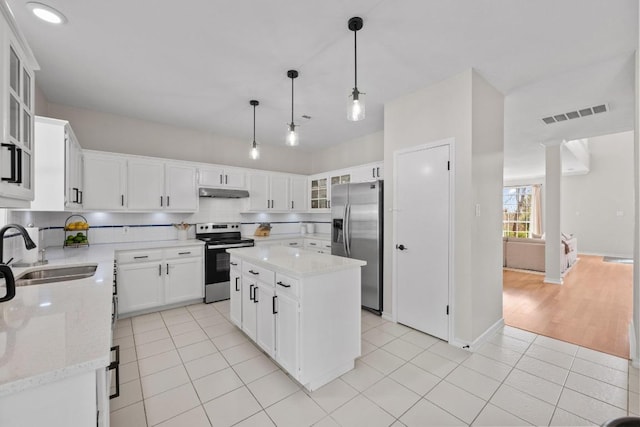 6202 Sotol Cv, Austin, TX 78759 - kitchen featuring stainless steel appliances, a sink, under cabinet range hood, light tile patterned floors, and a center island