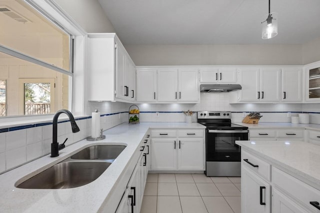 kitchen featuring decorative backsplash, stainless steel range with electric stovetop, under cabinet range hood, and a sink