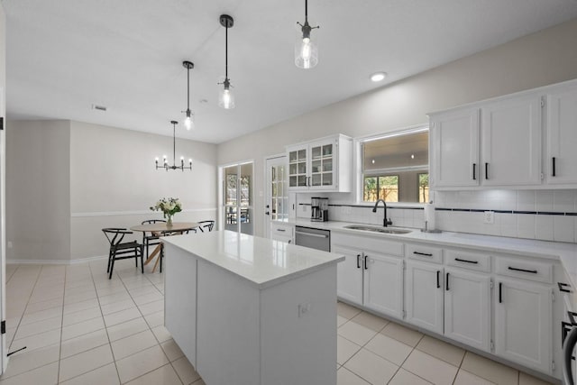 kitchen featuring light tile patterned floors, decorative backsplash, stainless steel dishwasher, and a sink