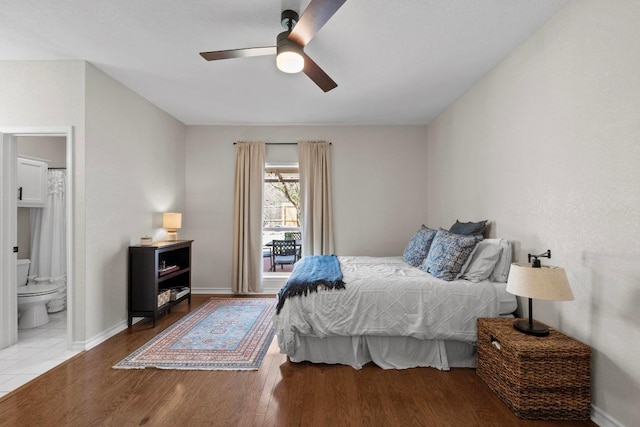 bedroom featuring ensuite bath, wood finished floors, baseboards, and ceiling fan