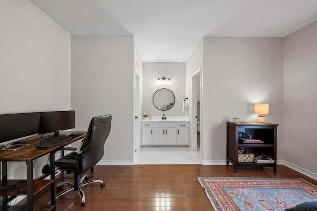 office area with light wood-style floors and baseboards