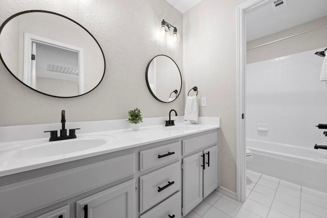 6202 Sotol Cv, Austin, TX 78759 - bathroom featuring double vanity, tile patterned floors, toilet, bathtub / shower combination, and a textured wall