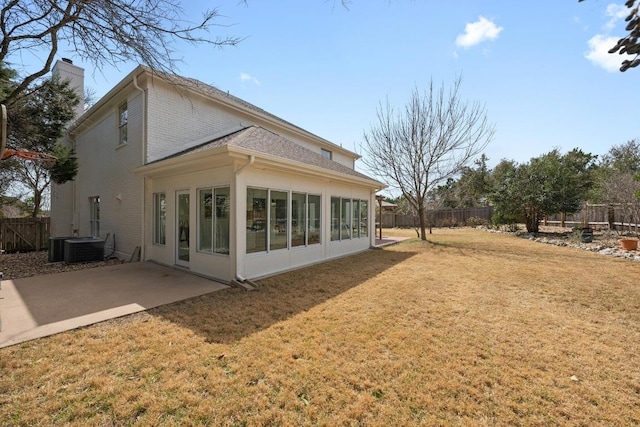 back of house featuring central AC unit, a chimney, a yard, a fenced backyard, and a patio area