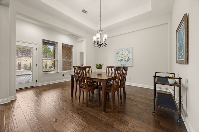 dining room with baseboards, visible vents, a raised ceiling, dark wood-style flooring, and an inviting chandelier