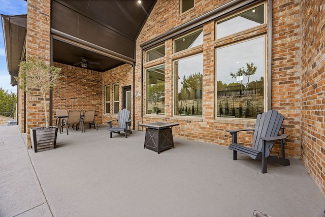 view of patio / terrace with outdoor dining space, ceiling fan, and a fire pit