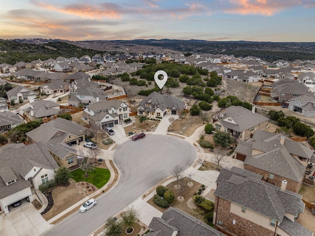 aerial view at dusk featuring a mountain view and a residential view