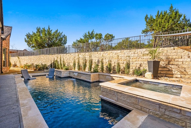 view of swimming pool with a fenced backyard and an in ground hot tub