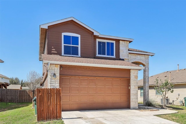 traditional home featuring a garage, driveway, a shingled roof, stone siding, and fence