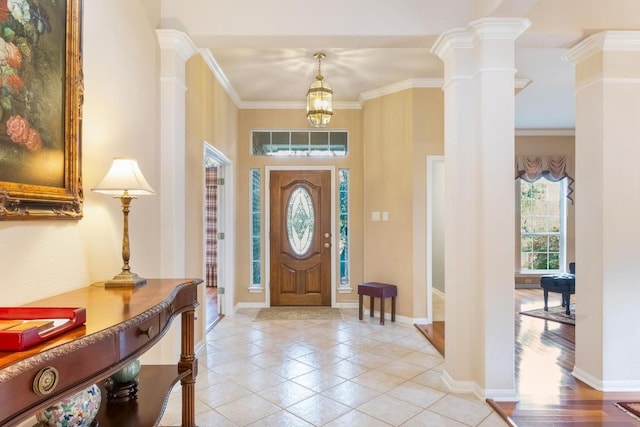 entrance foyer with ornate columns, baseboards, and crown molding