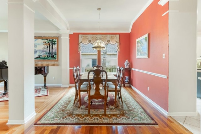 dining room featuring light wood-style flooring, a chandelier, baseboards, and ornamental molding