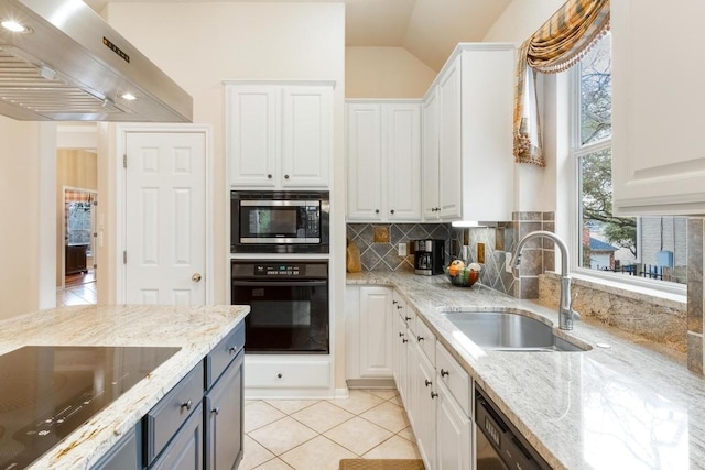 kitchen featuring black appliances, wall chimney exhaust hood, white cabinetry, and a sink