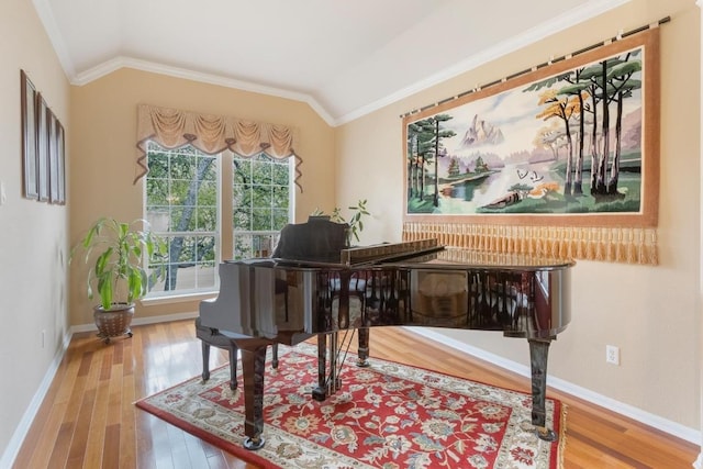 living area featuring ornamental molding, baseboards, vaulted ceiling, and hardwood / wood-style floors