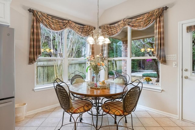 dining room with light tile patterned floors, a healthy amount of sunlight, baseboards, and an inviting chandelier