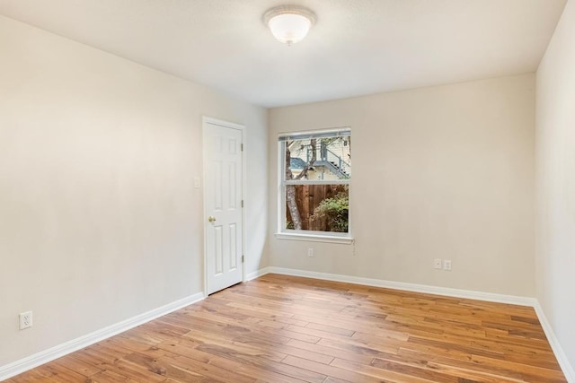 empty room with light wood-style flooring and baseboards