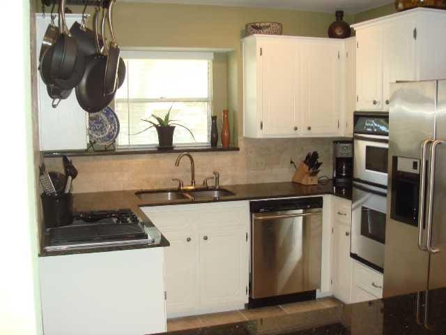 kitchen featuring a sink, white cabinets, appliances with stainless steel finishes, tasteful backsplash, and dark countertops