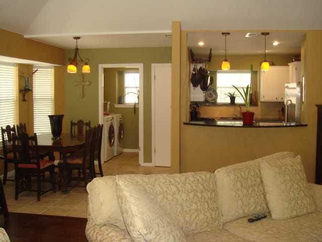 kitchen with freestanding refrigerator, white cabinets, a healthy amount of sunlight, and independent washer and dryer