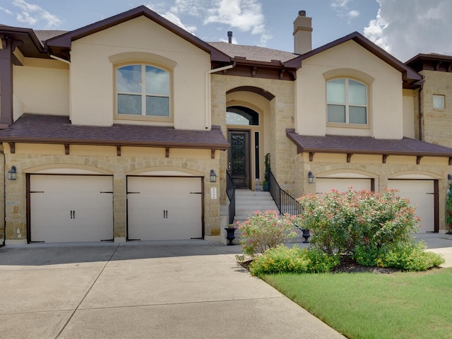 view of property with a garage, stone siding, concrete driveway, and stucco siding