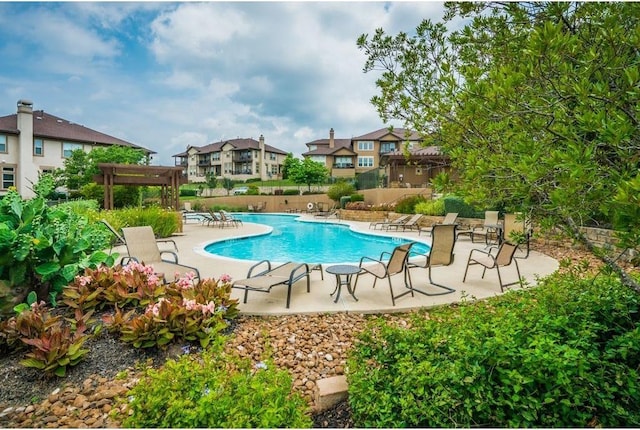 pool featuring a patio area, fence, and a residential view